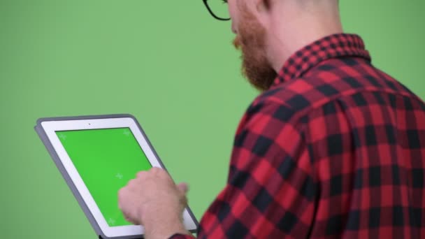 Zadní pohled na vousatého bokovky člověka s dredy pomocí digitálních tabletu — Stock video