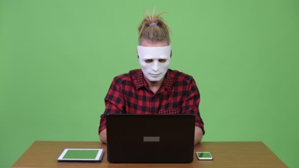 Hipster homem usando máscara como hacker contra mesa de madeira — Vídeo de Stock