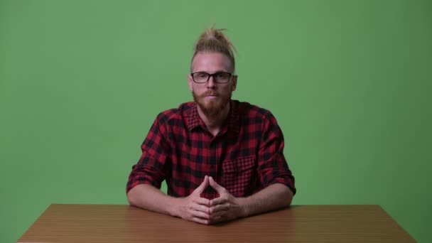 Knappe bebaarde hipster man geïnterviewd tegen houten tafel — Stockvideo