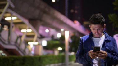 Geceleri şehir sokakları keşfetmek telefon kullanan İspanyol adam