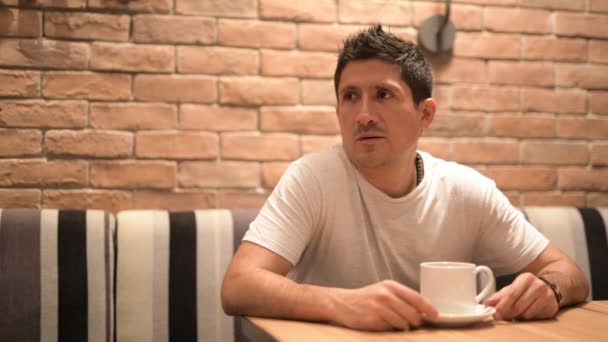 コーヒー ショップでリラックスしながら考えるヒスパニック系の人 — ストック動画