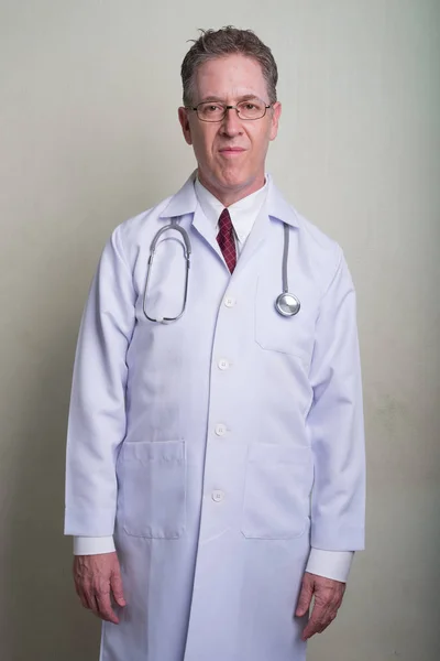 Beyaz arka plan karşı olgun adam doktor portresi — Stok fotoğraf
