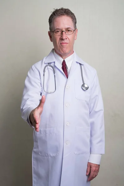 Érett férfi orvos fehér háttér portréja — Stock Fotó