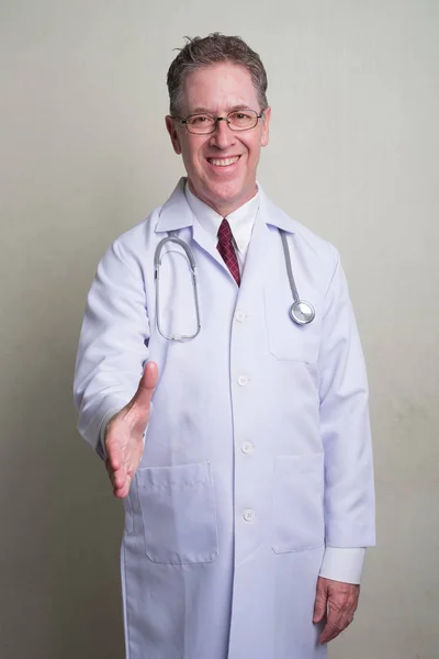 Portrét lékaře zralý muž proti bílým pozadím — Stock fotografie