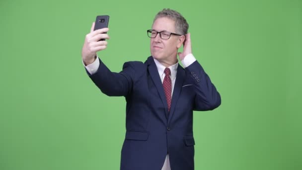 Studio colpo di maturo uomo d'affari prendendo selfie — Video Stock
