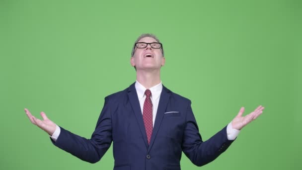 Studioaufnahme eines glücklichen reifen Geschäftsmannes, der etwas fängt — Stockvideo