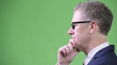 Chroma anahtar yeşil arka plana sahip karşı gri saçlı Olgun işadamı stüdyo çekim