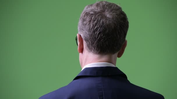 Головний знімок профілю зрілого бізнесмена, озираючись назад — стокове відео