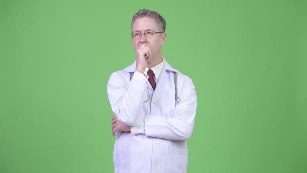Retrato de homem maduro médico pensando enquanto olha para cima — Vídeo de Stock