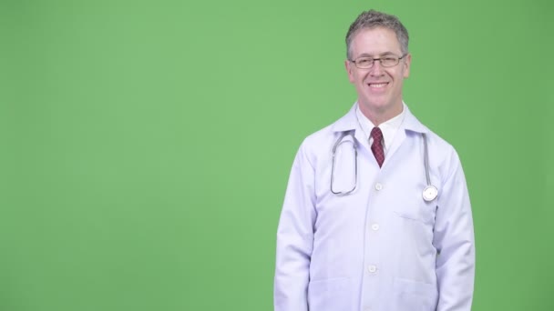 Porträtt av mogen man läkare visar något — Stockvideo