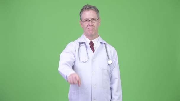 カメラを指している中年の男性医師の肖像画 — ストック動画