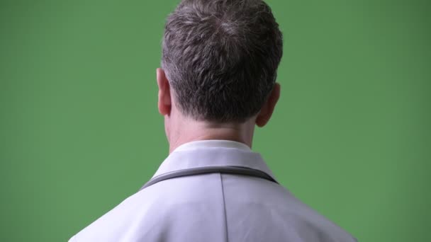 Vista trasera del médico hombre maduro con anteojos mirando hacia atrás — Vídeos de Stock