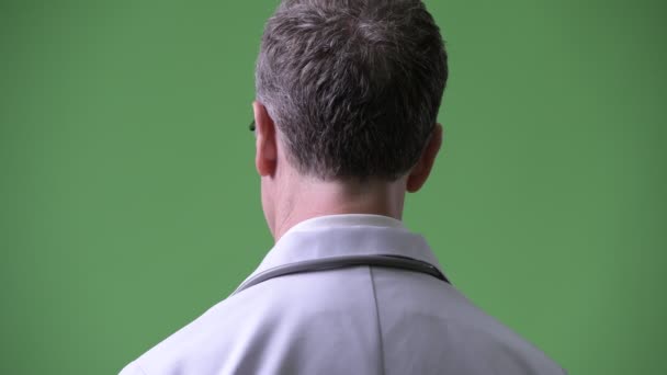 Visão traseira do homem maduro médico remoção de óculos e olhando para trás — Vídeo de Stock