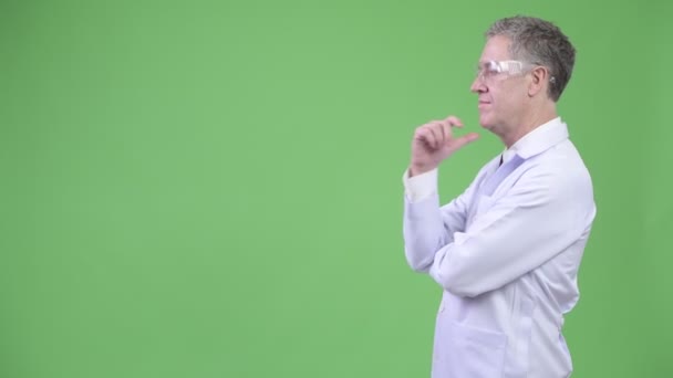 Vista de perfil del médico hombre maduro con gafas protectoras pensando — Vídeos de Stock