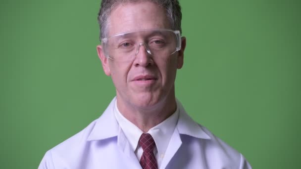 Volwassen man arts met een beschermende bril met een interview — Stockvideo