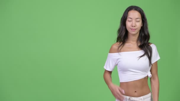 Unga glada vackra multietniska kvinna visar något — Stockvideo