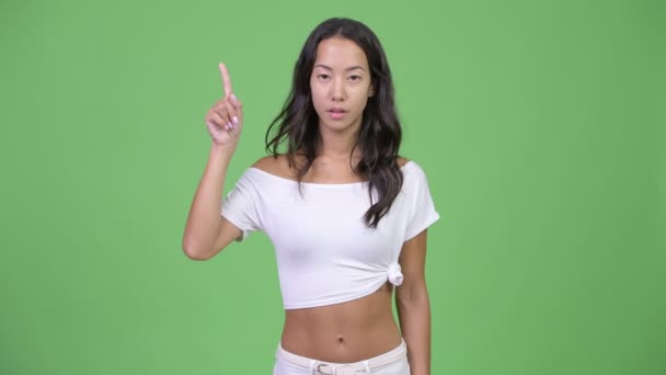 Young beautiful multi-ethnic woman pointing finger up — Stock Video