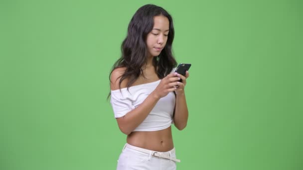 युवा खुश सुंदर बहुजातीय महिला फोन का उपयोग और अच्छी खबर प्राप्त करने — स्टॉक वीडियो