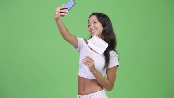 Jovem feliz bela mulher multi-étnica tomando selfie com sinal de papel — Vídeo de Stock