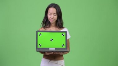 Gösterilen ve laptop arıyorum Genç mutlu güzel çok etnik gruptan oluşan bir kadın