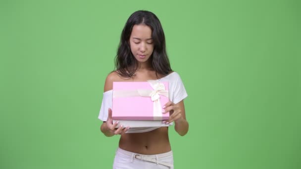 Молода щаслива красива багатоетнічна жінка відкриває подарункову коробку — стокове відео