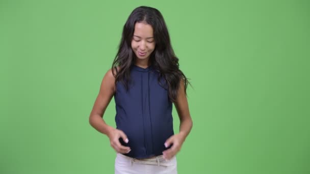 Unga glada gravida multietniska affärskvinna med hand hjärtat gest — Stockvideo