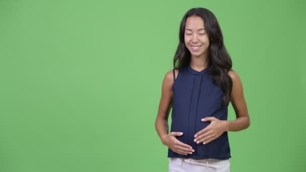 Unga glada gravida multietniska affärskvinna visar något — Stockvideo