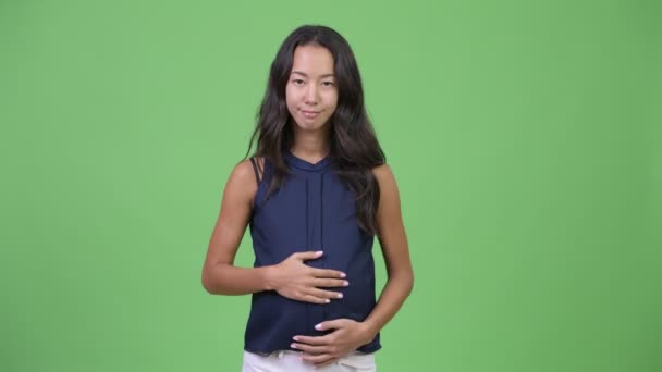 Young happy pregnant multi-ethnic businesswoman with finger on lips — Stock Video