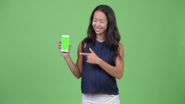 Junge glückliche schwangere multiethnische Geschäftsfrau zeigt Telefon — Stockvideo