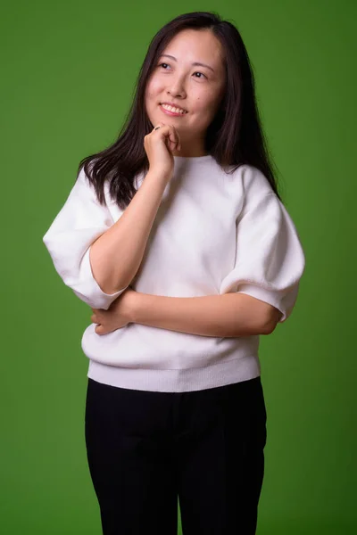 緑の背景に対して若い中国の女性 — ストック写真