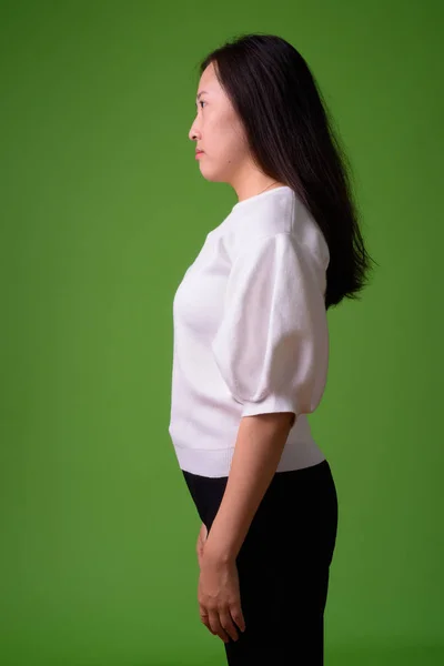Giovane donna cinese contro sfondo verde — Foto Stock