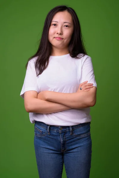 Giovane donna cinese contro sfondo verde — Foto Stock