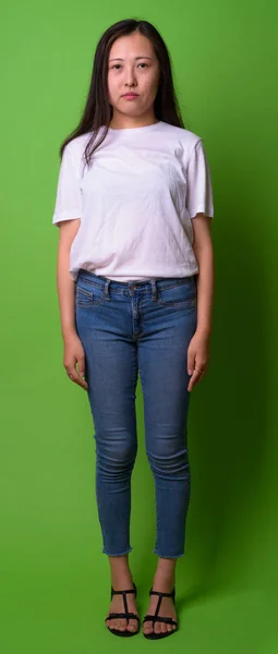 Young Chinese woman against green background — Stock Photo, Image