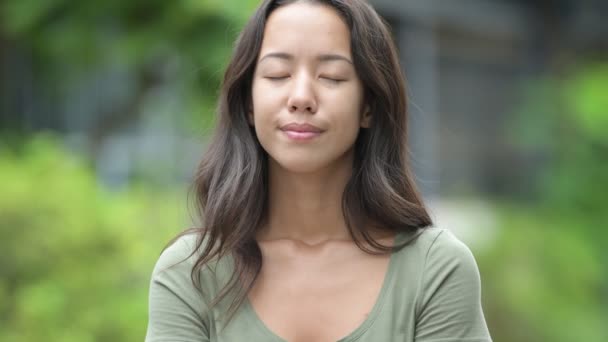 Молодая счастливая красивая многонациональная женщина расслабляется с закрытыми глазами на открытом воздухе — стоковое видео