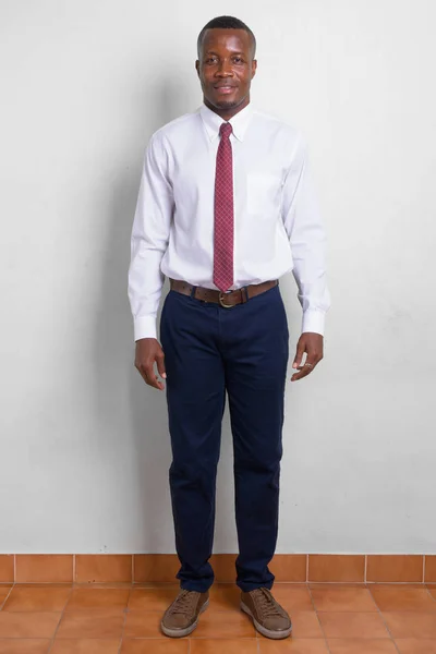 Full body shot di giovane felice uomo d'affari africano contro sfondo bianco — Foto Stock