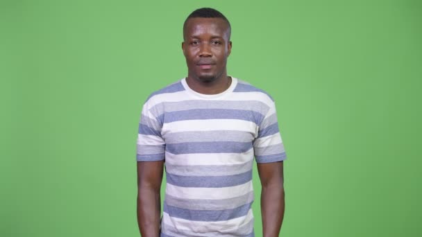 Jonge Afrikaanse man tegen een groene achtergrond — Stockvideo