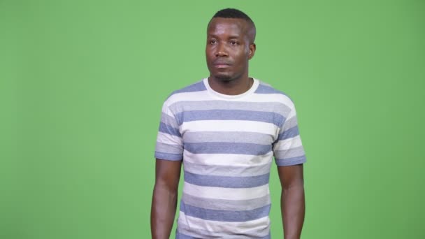 Junger afrikanischer Mann denkt vor grünem Hintergrund — Stockvideo