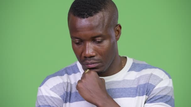 Joven hombre africano serio pensando mientras mira hacia abajo — Vídeo de stock