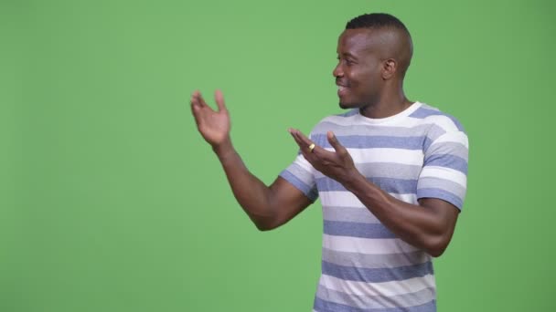 Genç mutlu Afrika adam bir şeyler gösteriyor — Stok video