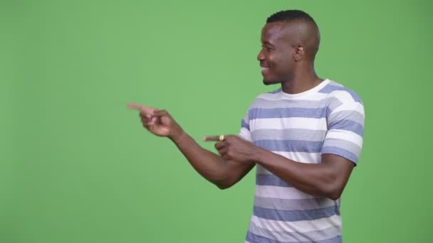 Šťastný afrického mladíka ukazuje něco — Stock video