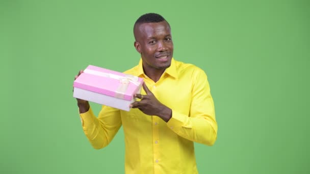 Jonge gelukkig Afrikaanse zakenman schudden geschenkdoos — Stockvideo