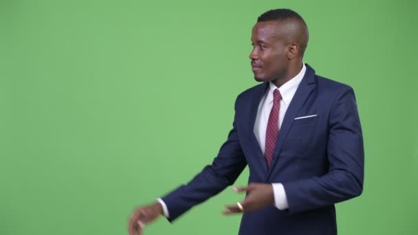 Junger glücklicher afrikanischer Geschäftsmann zeigt etwas — Stockvideo