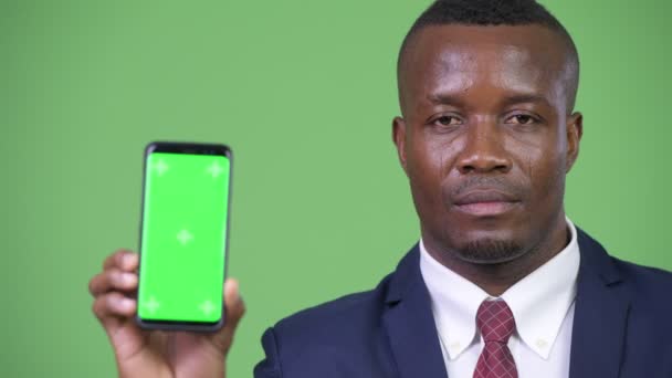 Giovane felice uomo d'affari africano mostrando telefono — Video Stock