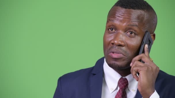 Jonge gelukkig Afrikaanse zakenman denken tijdens het gesprek op de telefoon — Stockvideo