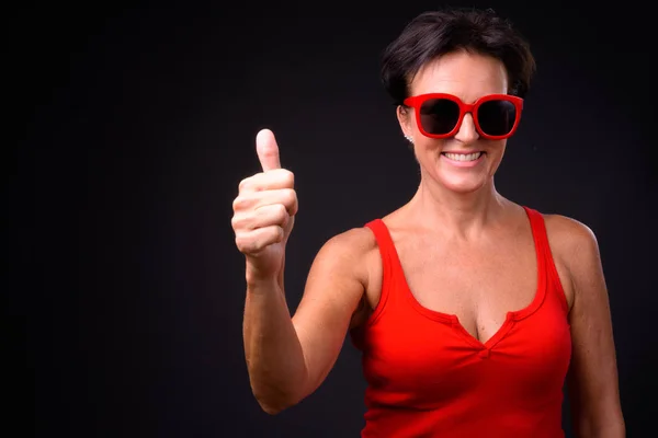 Reife schöne Frau mit kurzen Haaren vor schwarzem Hintergrund — Stockfoto