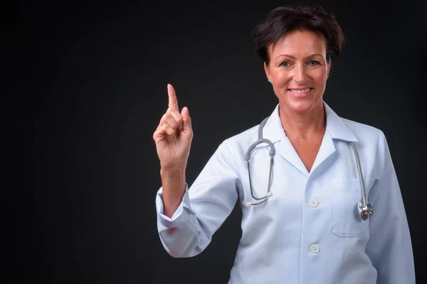 Maturo bella donna medico con i capelli corti contro la schiena nera — Foto Stock