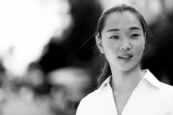 Young beautiful Asian businesswoman outdoors in black and white
