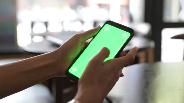 Primo piano della mano della donna che utilizza il telefono cellulare con schermo verde nel ristorante — Video Stock