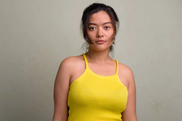 Joven hermosa mujer asiática usando amarillo sin mangas superior —  Fotos de Stock