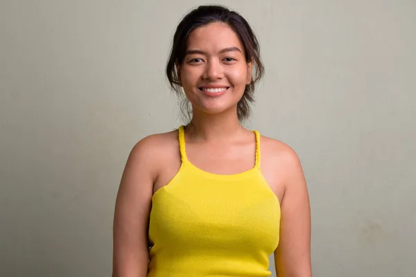 Giovane bella donna asiatica che indossa top senza maniche gialle — Foto Stock